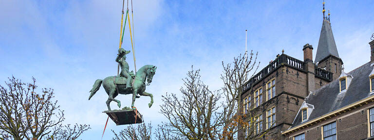 het ruiterstandbeeld van Willem II hangt aan kabels in de lucht bij de Mauritstoren