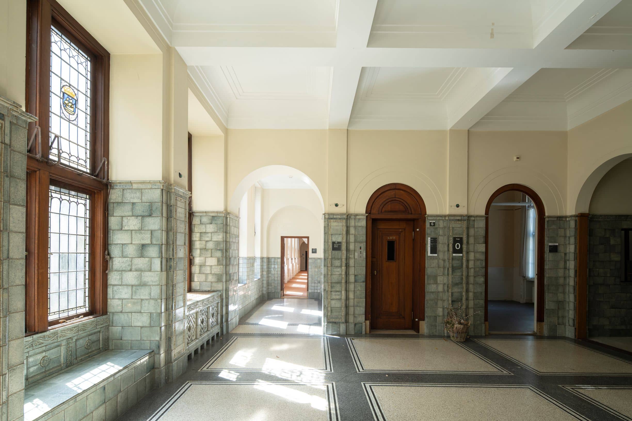 De rijk betegelde bel-etage van gebouw C voor de renovatie