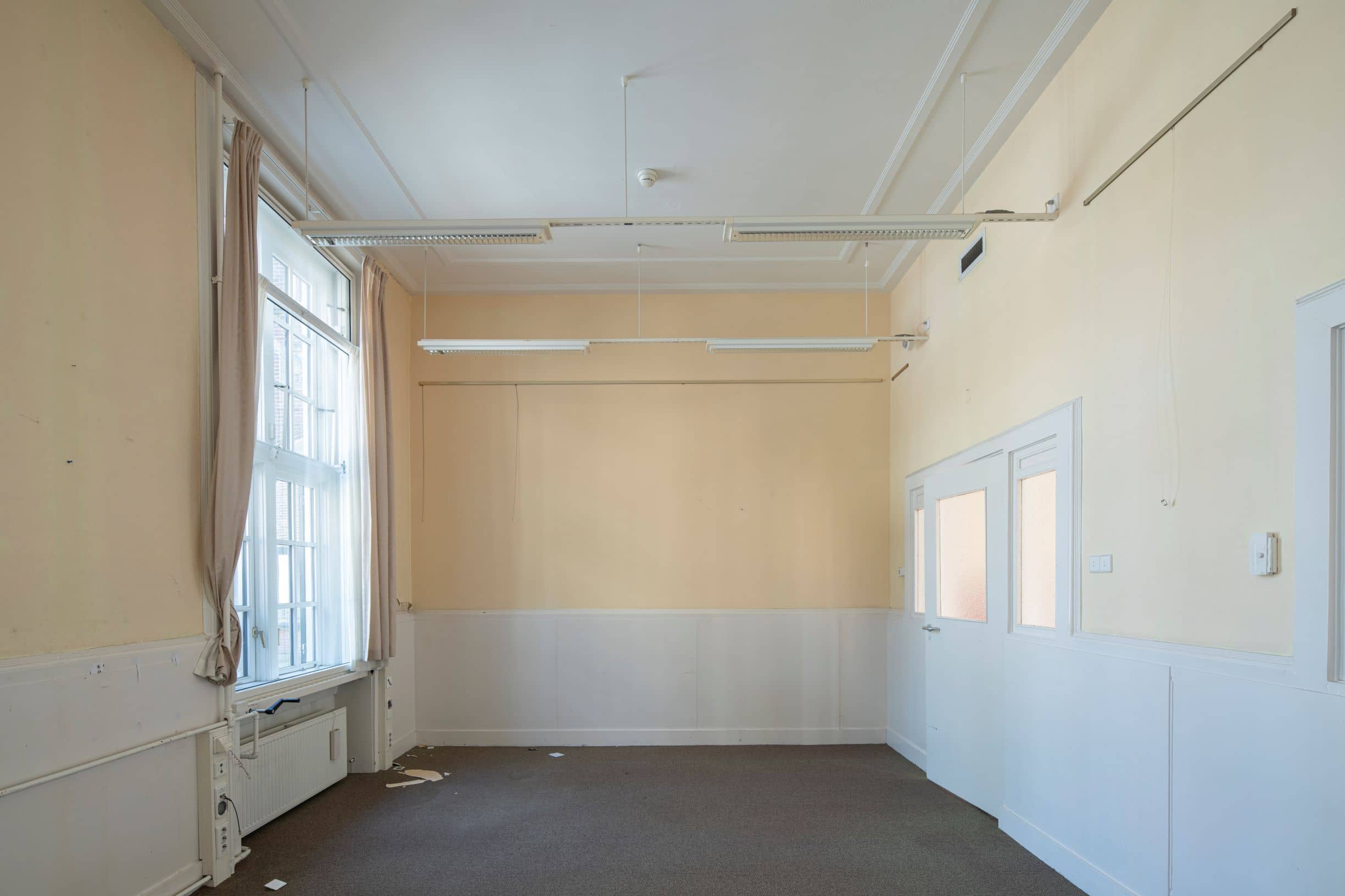 Beeld van ontruimde standaard werkruimte van gebouw C voor de renovatie