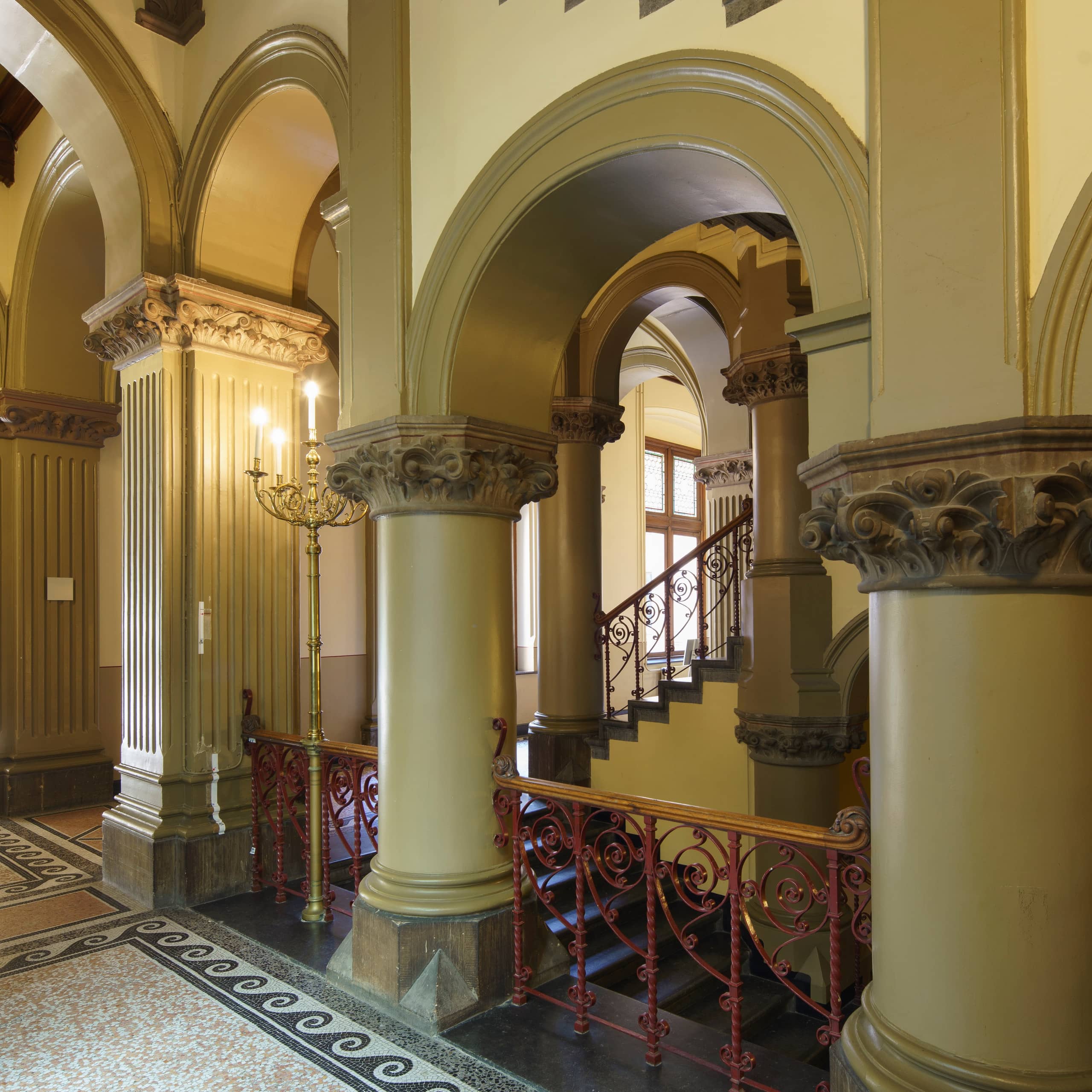 Trappenhuis gebouw J met prominente kolommen en bogen