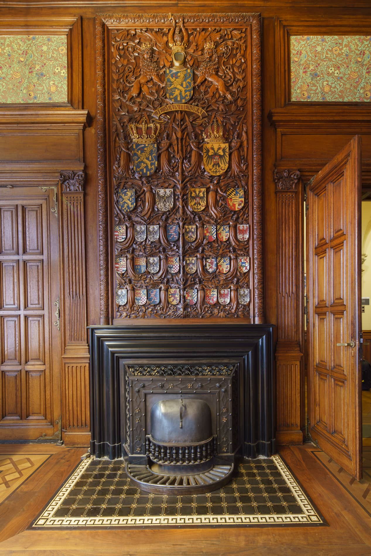 Rijkelijk met familiewapens gedecoreerde schouw in stijlkamer van gebouw J