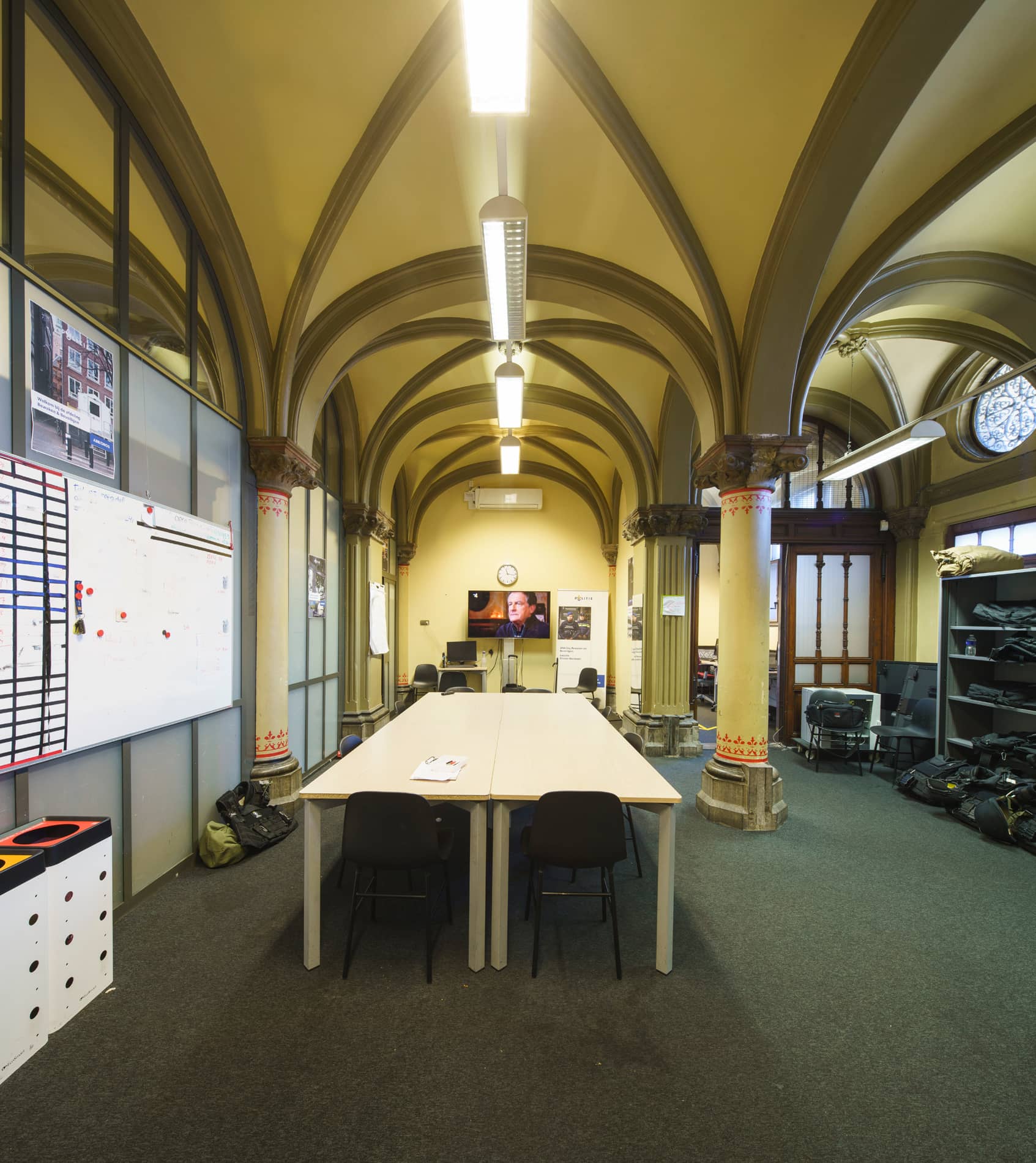 Vestibule gebouw J voor renovatie met lange tafel en planningsbord