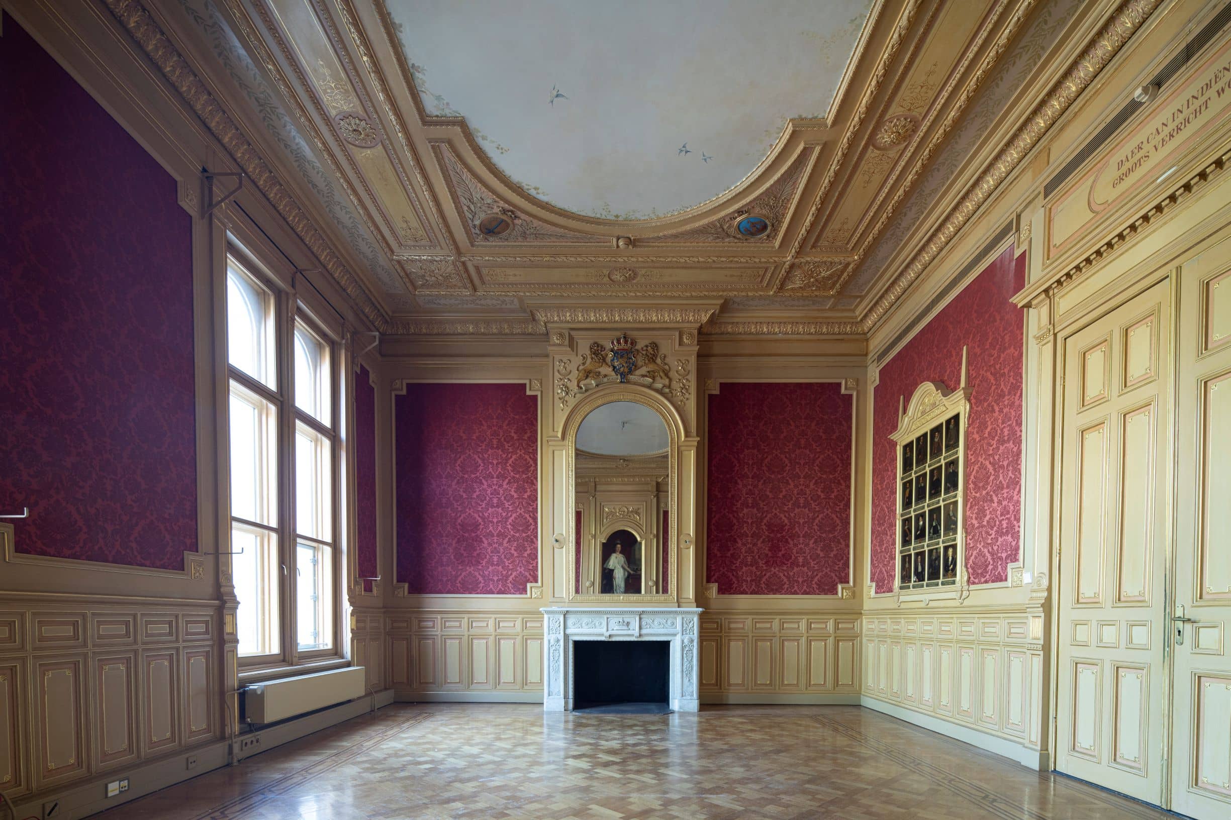 Rijkelijk versierde kamer met lambrizering, haardstuk en bewerkt plafond