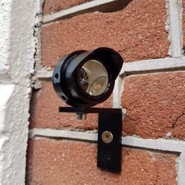 Monitoringsprisma Fidas op bakstenen muur van het Binnenhof