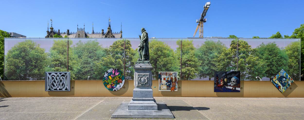 Het Plein in Den Haag met het standbeeld van Willem van Oranje en de bouwschutting met de vijf kunstwerken