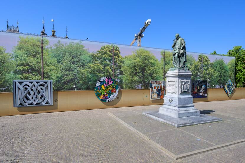 Het Plein in Den Haag met het standbeeld van Willem van Oranje en de bouwschutting met de vijf kunstwerken