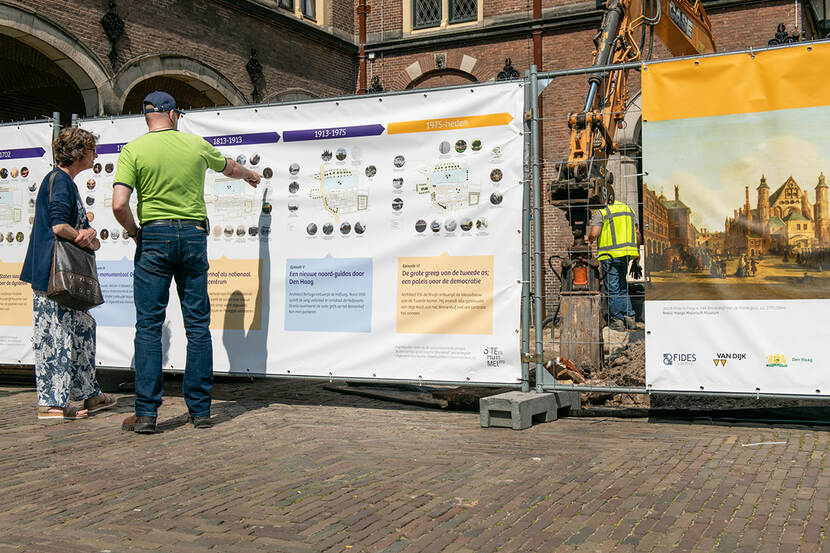 Mensen voor bouwschutting op het Binnenhof