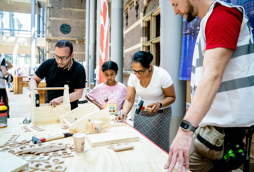 Ouders en kind timmeren kistje in Statenpassage - Dag van de Bouw / Dag van de Architectuur op het Binnenhof - 17 juni 2023