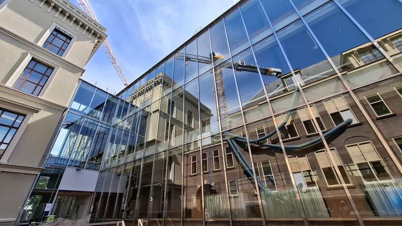 Spiegelende gevel van gebouw N van de Tweede Kamer, met weerspiegeld gebouw K en gebouw C