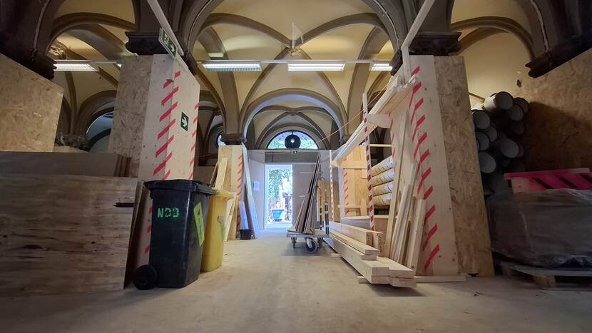 Gewelfde ruimte met afgetimmerde kolommen en gevuld met opslagmateriaal