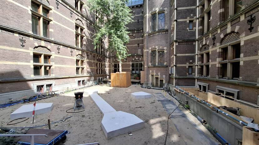 Patio gebouw J met boom en drie betonnen funderingsplaten