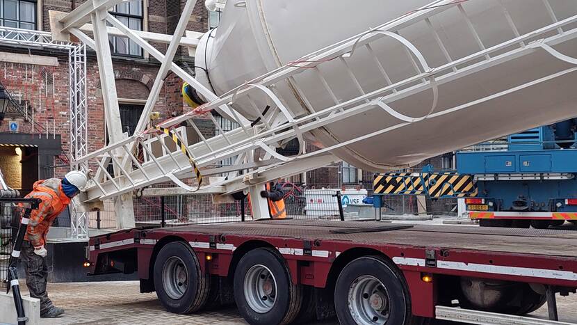 Bij de Stadhouderspoort wordt een cementmixer op een dieplader getakeld