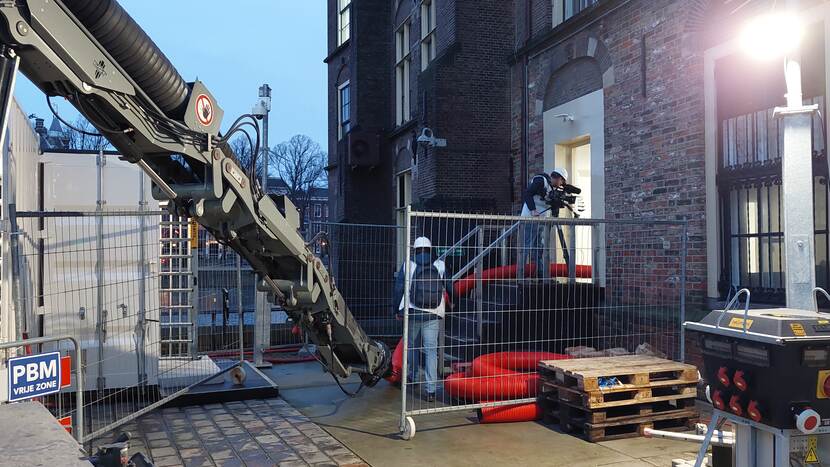 Een cameraman is aan het filmen door een deur naast de Mauritstoren