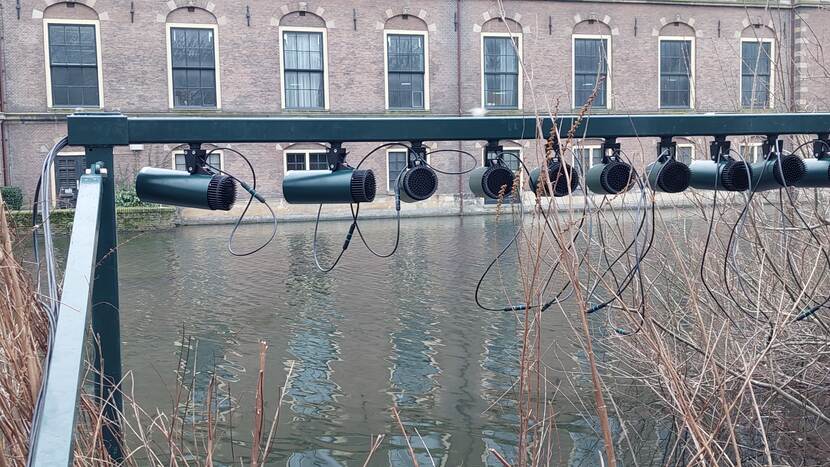 Tien lampen hangend aan een constructie op het eiland in de Hofvijver