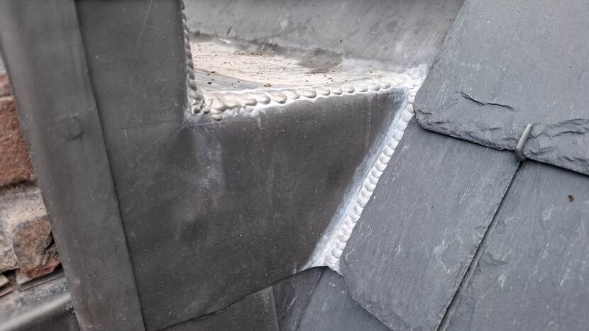Leien naast een gesoldeerde dakgoot bij gebouw C van de Tweede Kamer