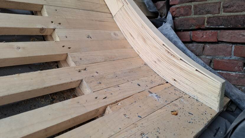 Dunnen latjes volgen de afronding van het dak bij gebouw C van de Tweede Kamer