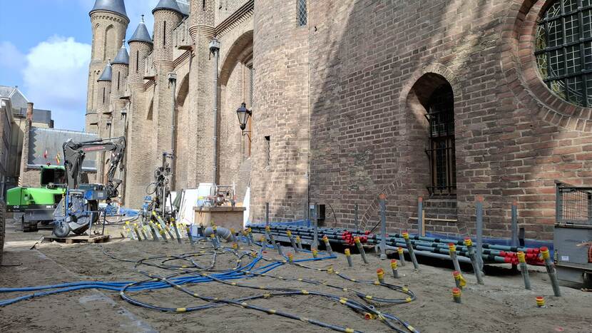 Tientallen plastic buizen steken uit de grond langs de geven van de Ridderzaal