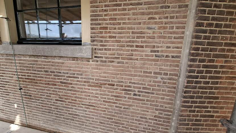 Gemetselde muur met onderkant van raam bij gebouw A van de Tweede Kamer