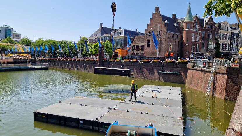 Pontons liggen in de Hofvijver bij de Gevangenenpoort, één ponton wordt uit het water gehesen