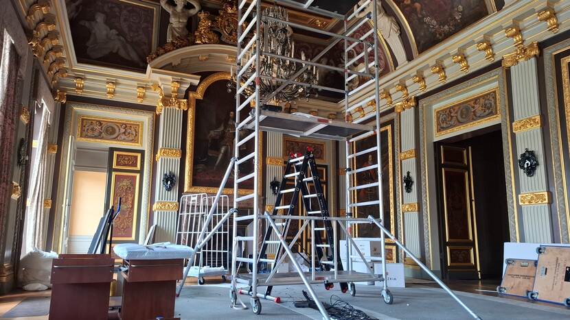 Een verrijdbare steiger bij een kroonluchter in de Trêveszaal