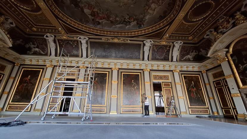Een rolsteiger in de Trêveszaal, op de achtergrond de portretten van de stadhouders