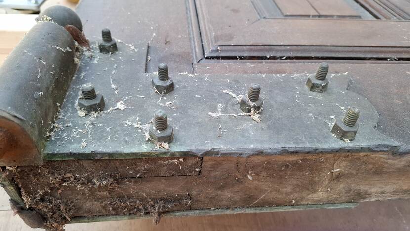 Houten deur met stevig, door zeven bouten bevestigd scharnier