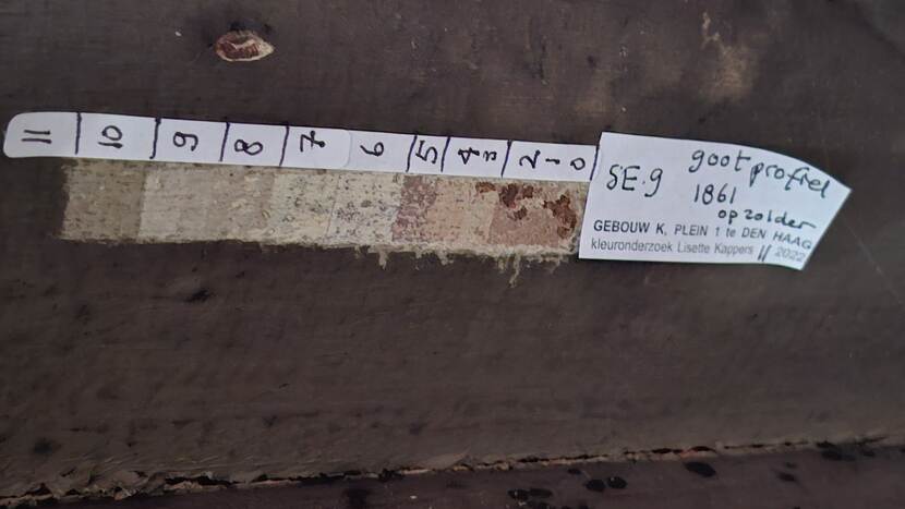 Kleuronderzoek in gebouw K; verschillende kleurlagen zijn genummerd met een sticker erbij 'gootprofiel zolder'
