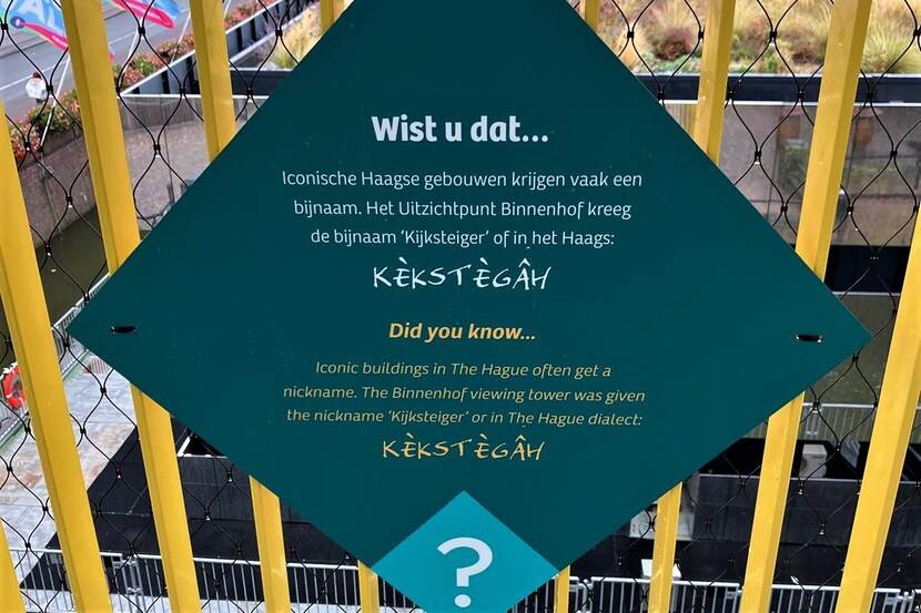 wiebervormig bord met tekst 'kèkstegâh' in lettertype van de strip Haagse Harry