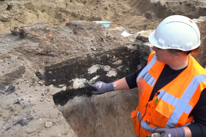 Archeoloog Mignonne Lenoir wijst de zandlensjes in de grondlaag aan