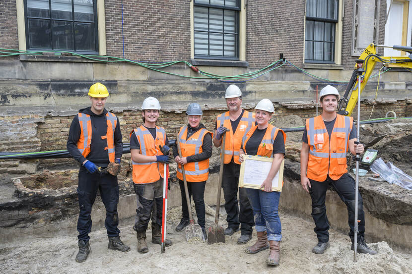 De zes leden van het team veldwerk archeologie Hofkapel staan tussen de opgravingen