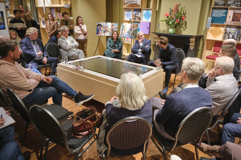 Minister Hugo de Jonge en wethouder Saskia Bruines praten in het Informatiecentrum Binnenhof Renovatie met bewoners en ondernemers uit de buurt