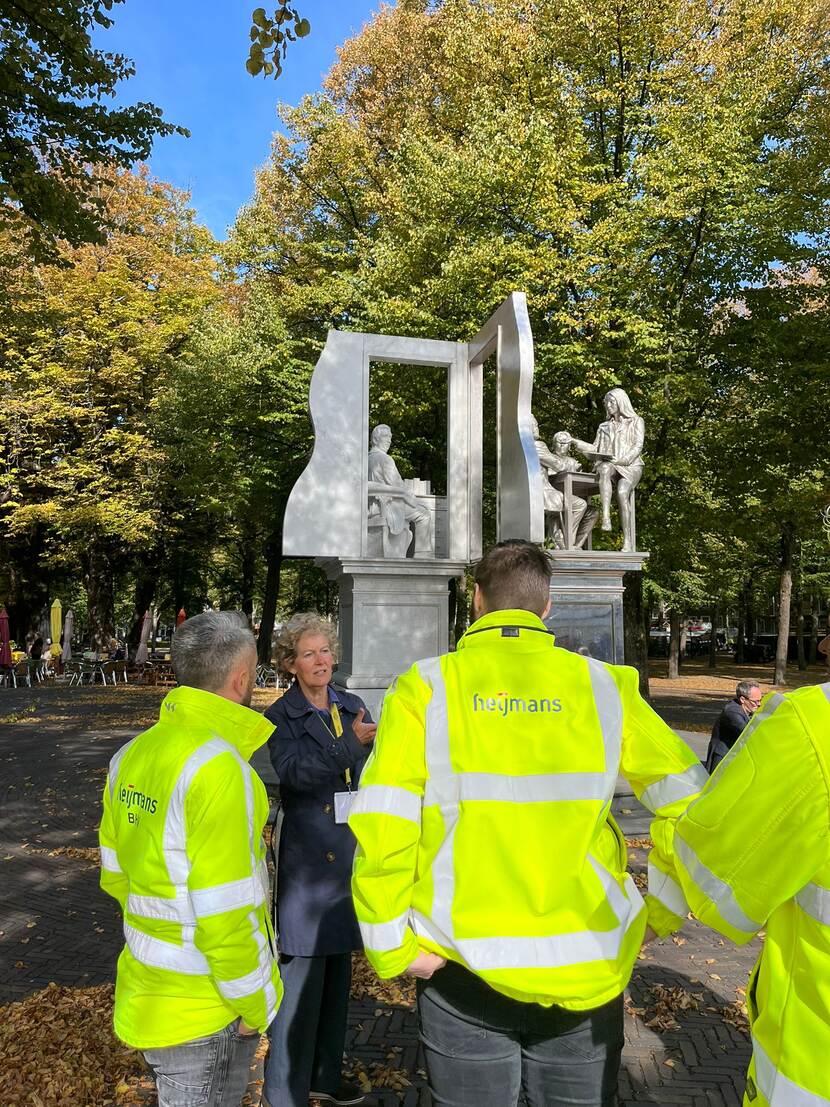 Renée de Krom van ProDemos met bouwmedewerkers bij het standbeeld van Thorbecke