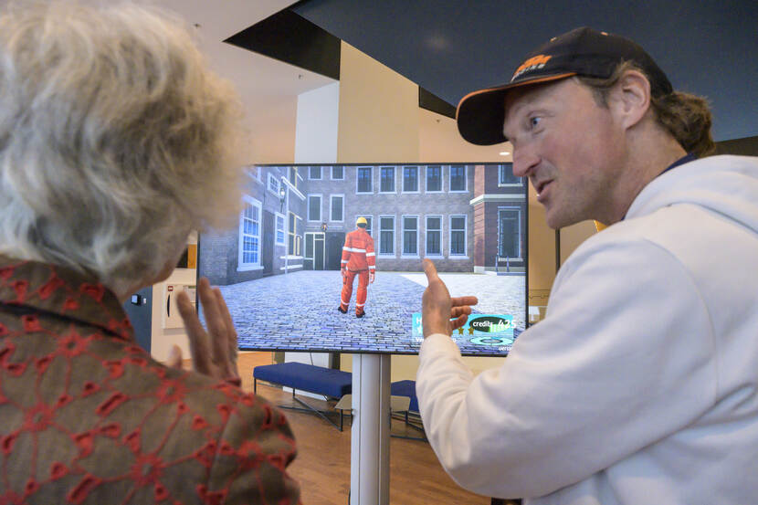 Architect Joep Mol presenteert het ontwerp voor de Eerste Kamer, op het beeldscherm is een doorsnede over de plenaire zaal te zien