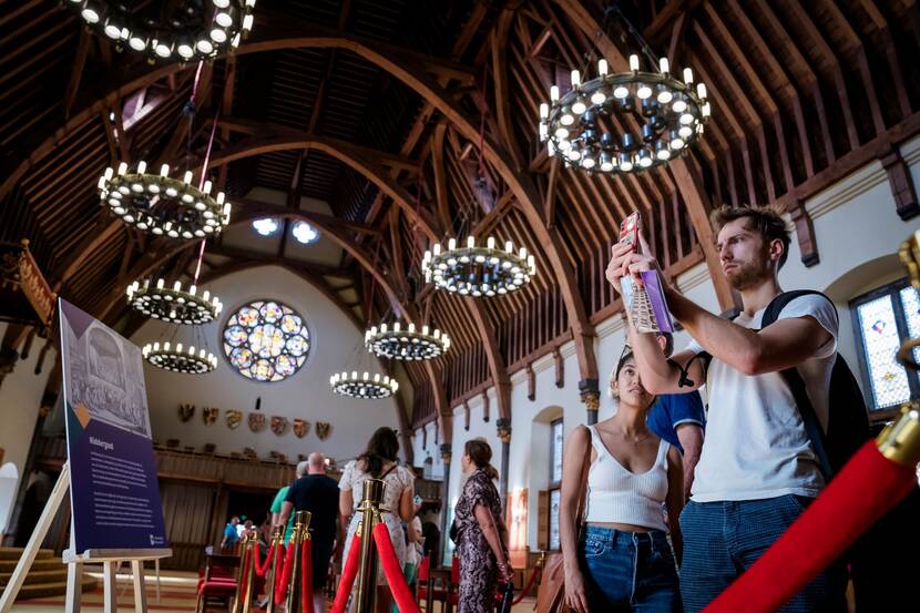 Bezoekers nemen foto's in de Ridderaal tijdens Open Monumentendag Binnenhof 2023