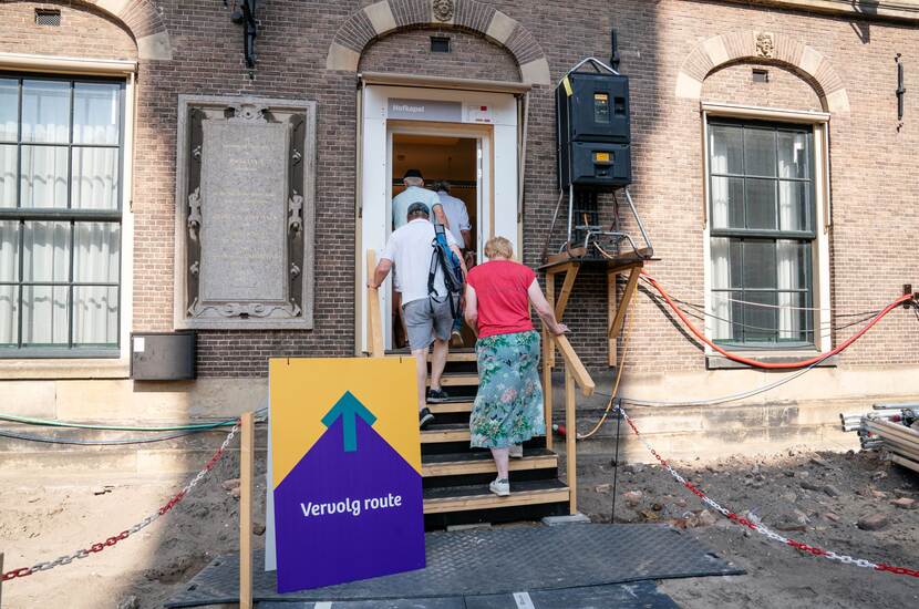 Bezoekers lopen een houten trapje op naar de ingang van de Hofkapel op Open Monumentendag Binnenhof 2023