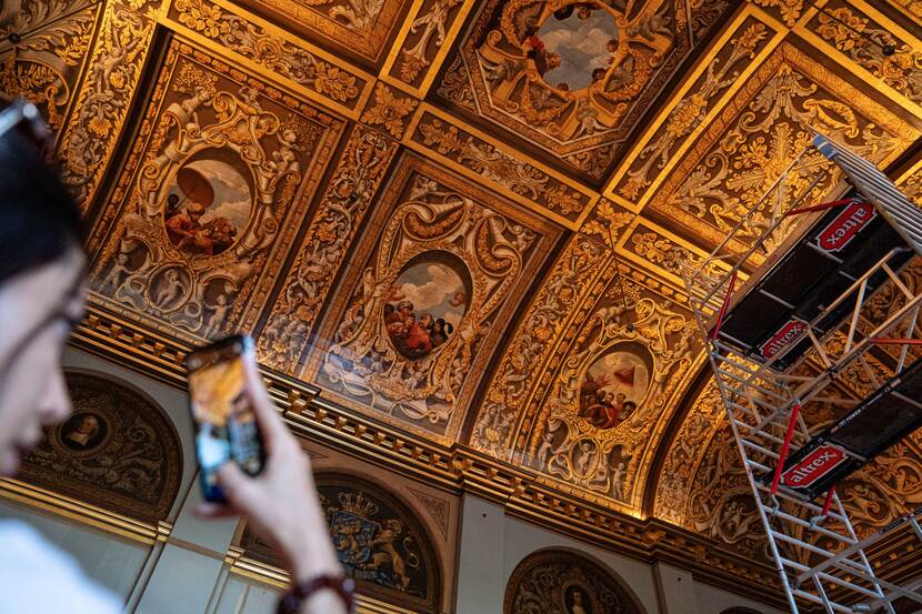 Bezoeker neemt een foto van het beschilderde plafond van de plenaire zaal van de Eerste Kamer op Open Monumentendag Binnenhof 2023