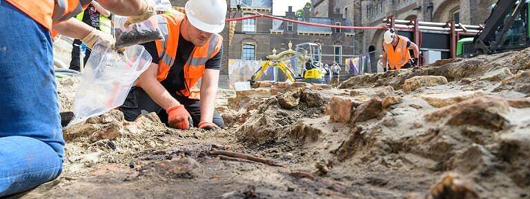 Archeologen buigen zich over skeletresten in de grond onder de voormalige Hofkapel op het Binnenhof